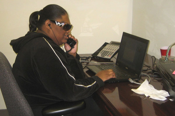Intern Laridda talks on the phone while at her desk